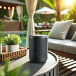 A compact, waterproof Bluetooth speaker on a modern outdoor table surrounded by greenery, showcasing its stylish and portable design